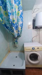 een kleine badkamer met een toilet en een douchegordijn bij Run İn Joy Hostel in Qostanaj +8 foto's