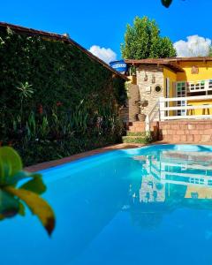 a blue swimming pool in front of a house at Pousada das Arvores in Lençóis