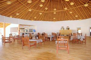 a dining room with tables and chairs and a ceiling at King baobab lodge in Diakhanor