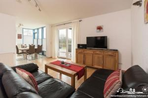 a living room with a couch and a tv at 18 Ferienwohnung im Fritz-Bleyl-Weg 16a EG in Burg auf Fehmarn