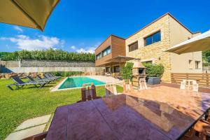 a backyard with a swimming pool and a house at Villa California - Costa Brava - Platja d'Aro in el Mas Vila