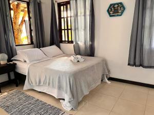 a room with a bed and a table with bows at Praia Comprida Flats in Abraão
