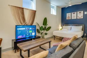 a living room with a couch and a tv at Bright and Modern Studio in Louisville # 109 in Louisville