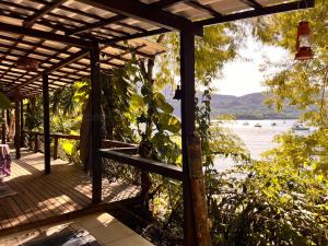 a wooden deck with a view of the water at Praia Comprida Flats in Abraão