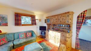 a living room with a couch and a wooden cabinet at Apartment Ambretta OG in Champfer