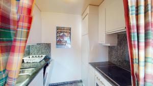 a small kitchen with white cabinets and a sink at Apartment Ambretta OG in Champfer