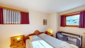 a bedroom with two beds and a window at Apartment Ambretta OG in Champfer +2 photos