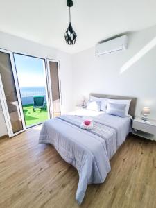 a bedroom with a large bed and a large window at Casa Caromba, Sunset in Prazeres