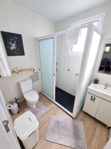a white bathroom with a toilet and a sink at Casa Caromba, Sunset in Prazeres