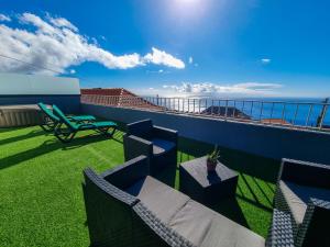 a balcony with chairs and a table and a view of the ocean at Casa Caromba, Sunset in Prazeres