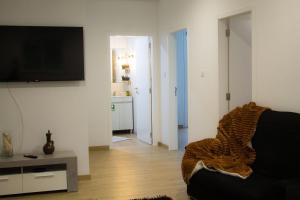 a living room with a couch and a flat screen tv at Casa Caromba, Sunset in Prazeres