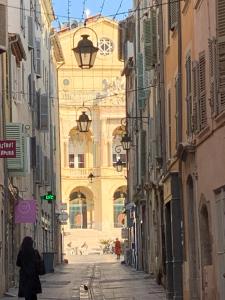a woman walking down a street between two buildings at Operappart 2 in Toulon