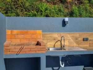 a kitchen with a sink and a brick wall at Casa Caromba, Sunset in Prazeres +25 photos