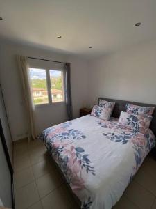 a bedroom with a bed with pillows and a window at Maison jasmin Porto Vecchio in Porto-Vecchio