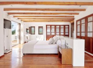 a bedroom with a white bed and a television at Villa Munt Blanc Ibiza in Puig D’en Valls