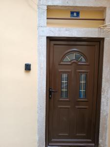 a brown door on a building with a sign above it at Tatiana's Town Studio in Corfu