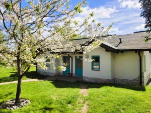 una pequeña casa blanca con un árbol en el patio en Pension Landhaus Teichgraf, en Wolgast
