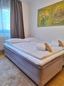 a bed in a bedroom with a painting on the wall at Apartman Lory, Zagreb, Downtown, with own parking in the garage in Zagreb
