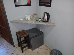 a kitchen with a counter and a stool under a counter top at Grand Central Guesthouse in Rustenburg
