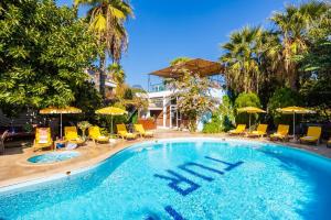 una gran piscina con sillas y sombrillas en Garden Bloom Hotel, en Dalyan