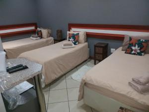 a room with two beds and a table at Grand Central Guesthouse in Rustenburg +68 photos