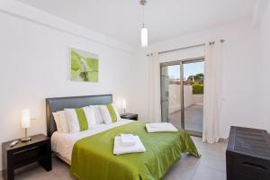 a bedroom with a bed with a green blanket at Albufeira Sunny Apartment 3 With Pool by Homing in Albufeira