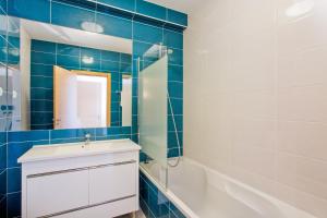 a bathroom with a sink and a tub and a mirror at Albufeira Sunny Apartment 3 With Pool by Homing in Albufeira +4 photos