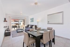 a dining room with a table and chairs and a couch at Albufeira Sunny Apartment 3 With Pool by Homing in Albufeira