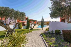 a garden with a pathway and trees and a pool at Albufeira Sunny Apartment 3 With Pool by Homing in Albufeira
