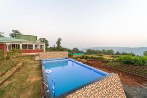 una piscina en un patio al lado de una casa en Strawberry King Resort, en Mahabaleshwar