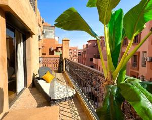 a balcony with a bench and a plant on a balcony at Piscine Guéliz Center Yoga in Marrakech