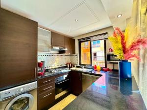 a kitchen with a washing machine and a vase with flowers at Piscine Guéliz Center Yoga in Marrakech