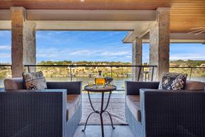 a porch with two chairs and a table with a view at Lake Marble Falls on The Rocks and Concierge Service in Marble Falls