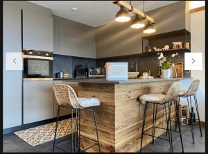 a kitchen with a counter with two stools at a bar at Résidence Robin des Bois, Crans-Montana, luxueux appartement avec vue imprenable in Crans-Montana +14 photos