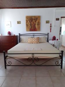 a large bed in a bedroom with a painting on the wall at Maria's Home in Kakovatos
