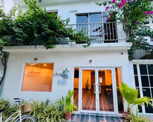 a view of the front of a white building with a balcony at Ramzu Villa Thoddoo in Thoddoo