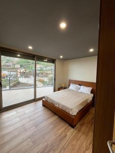 a bedroom with a bed and a large window at Sunset Valley House in Ribeira Brava +24 photos