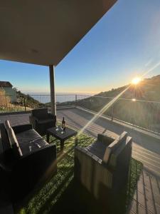 eine Terrasse mit Stühlen und einem Tisch auf einem Balkon in der Unterkunft Sunset Valley House in Ribeira Brava + 24 Fotos