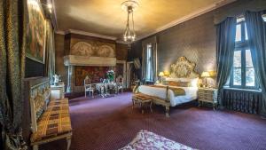 a bedroom with a bed and a table in it at Château de Codignat in Lezoux +118 photos