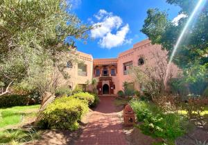 a large house with a brick driveway at Paradis à marrakech Grande Piscine in Marrakech
