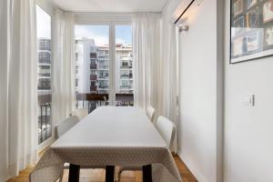 a white table and chairs in a room with a window at Spacious Apartment T3 Near Beach in Estoril