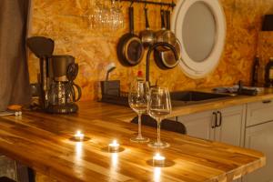 two wine glasses sitting on a wooden table with candles at Magnifique Péniche cosy et spacieuse à Toulouse in Toulouse +29 photos