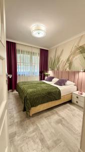 a bedroom with a large bed with a green blanket at Dolina Wikingów-apartament typu Suite Deluxe z 16 m tarasem w ogrodzie, miejscem w garażu i dostępem do strefy Wellness in Szklarska Poręba