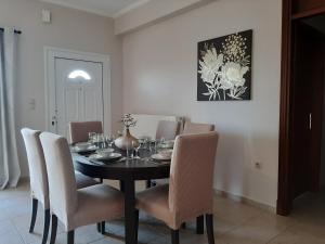 a dining room with a black table and chairs at Villa Sunrise apartment in Gouvia