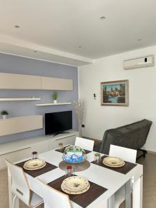 une salle à manger avec une table et des chaises blanches dans l'établissement Refrésh House, à Brindisi