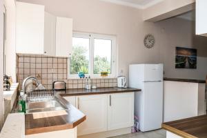 a kitchen with a sink and a refrigerator at Villa Sunrise apartment in Gouvia