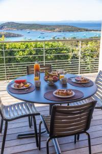 a blue table with food and drinks on a deck at Résidence Les Terrasses de Rondinara in Bonifacio