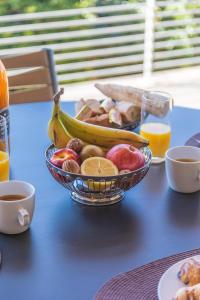 a bowl of fruit on a table with oranges and apples at Résidence Les Terrasses de Rondinara in Bonifacio