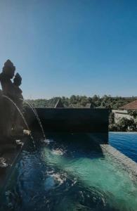 a couple sitting next to a water fountain at The balangan studio room 3mins to balangan beach in Uluwatu