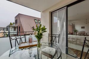 a glass table with a vase of flowers on a balcony at Nid calme centrale petite France in Strasbourg